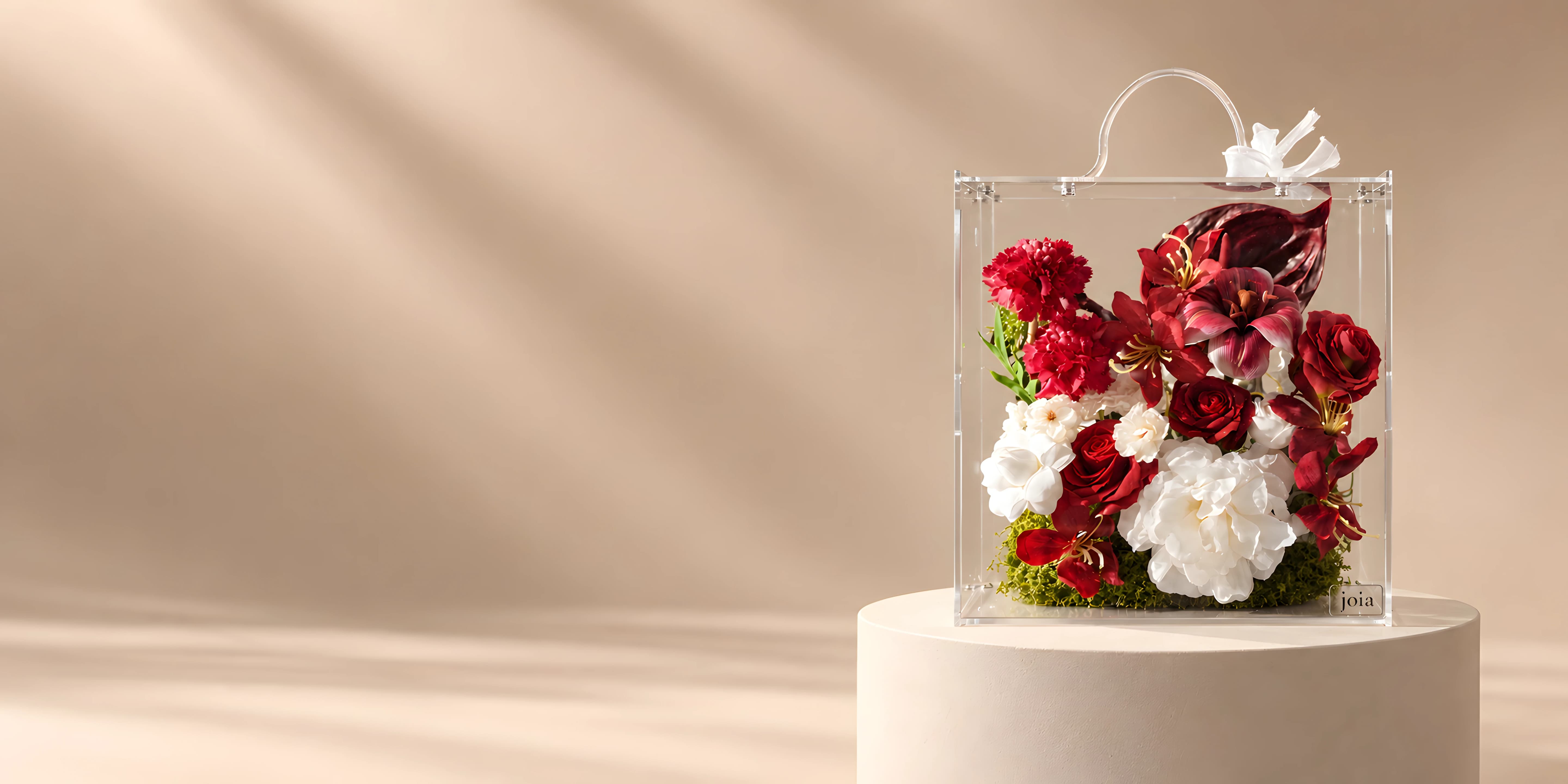 Red and burgundy JOIA Eternal Flower arrangement in a clear valise