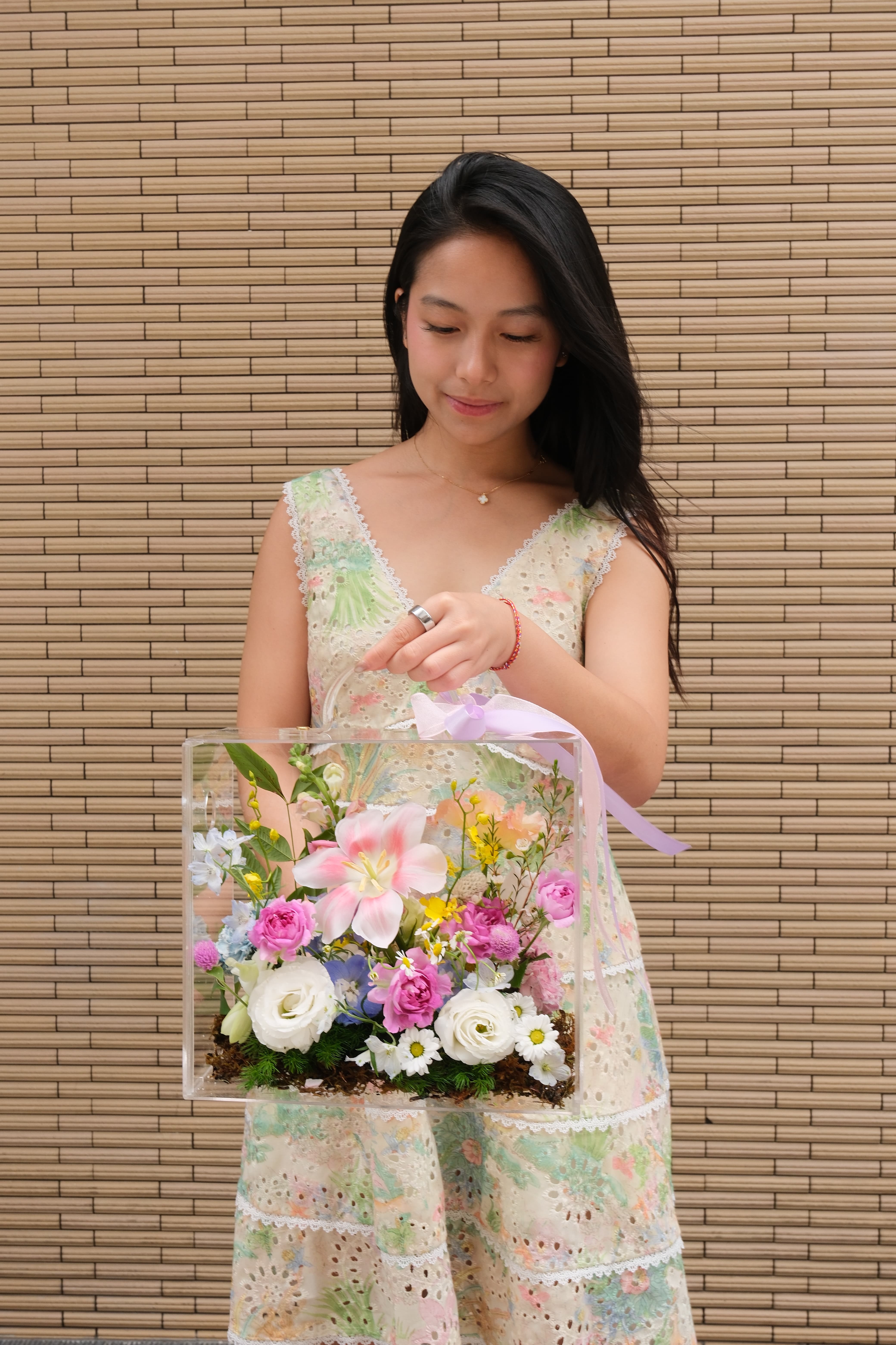Holding a JOIA valise filled with pastel flowers