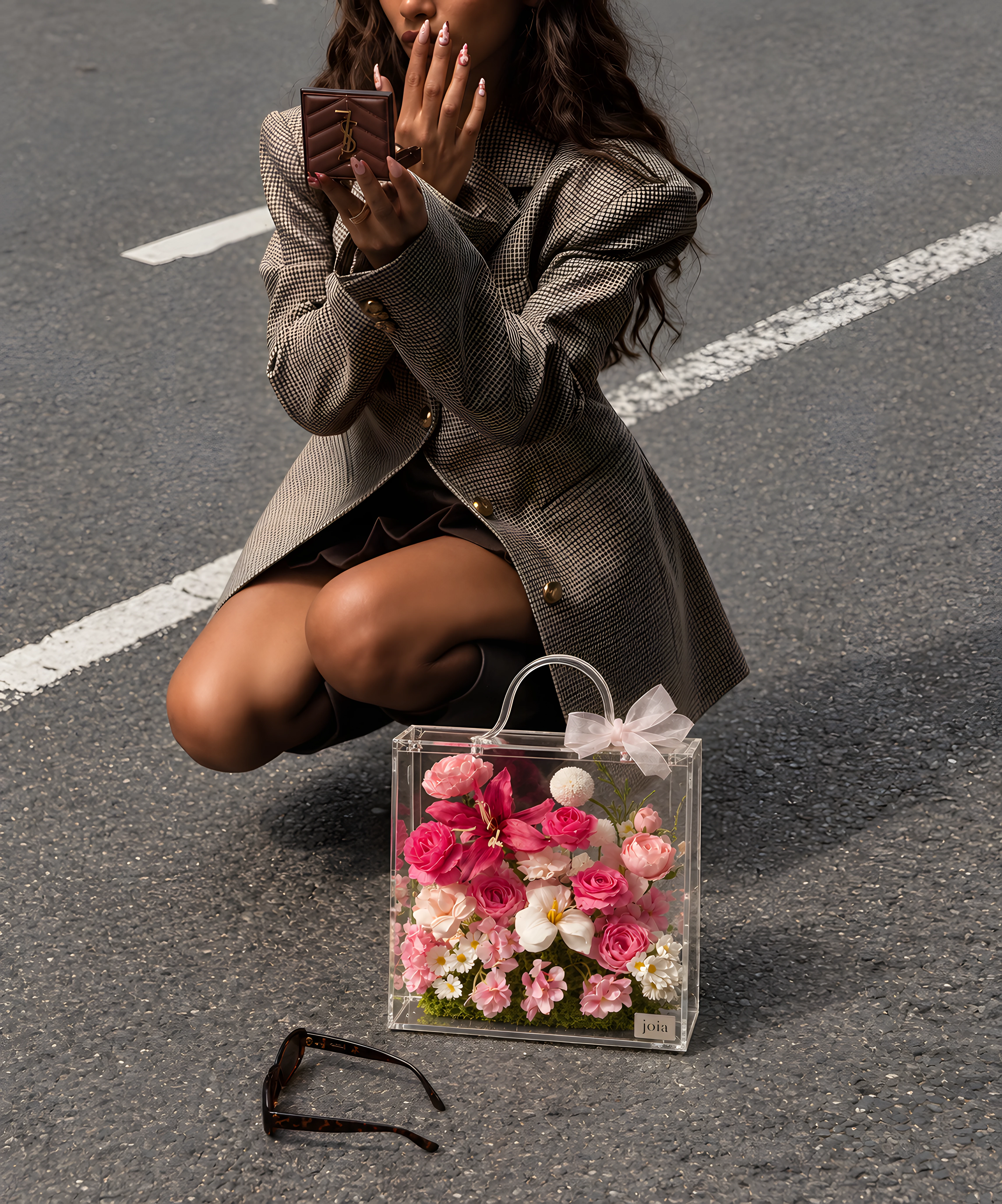 Pink JOIA flower valise beside a woman on a city street