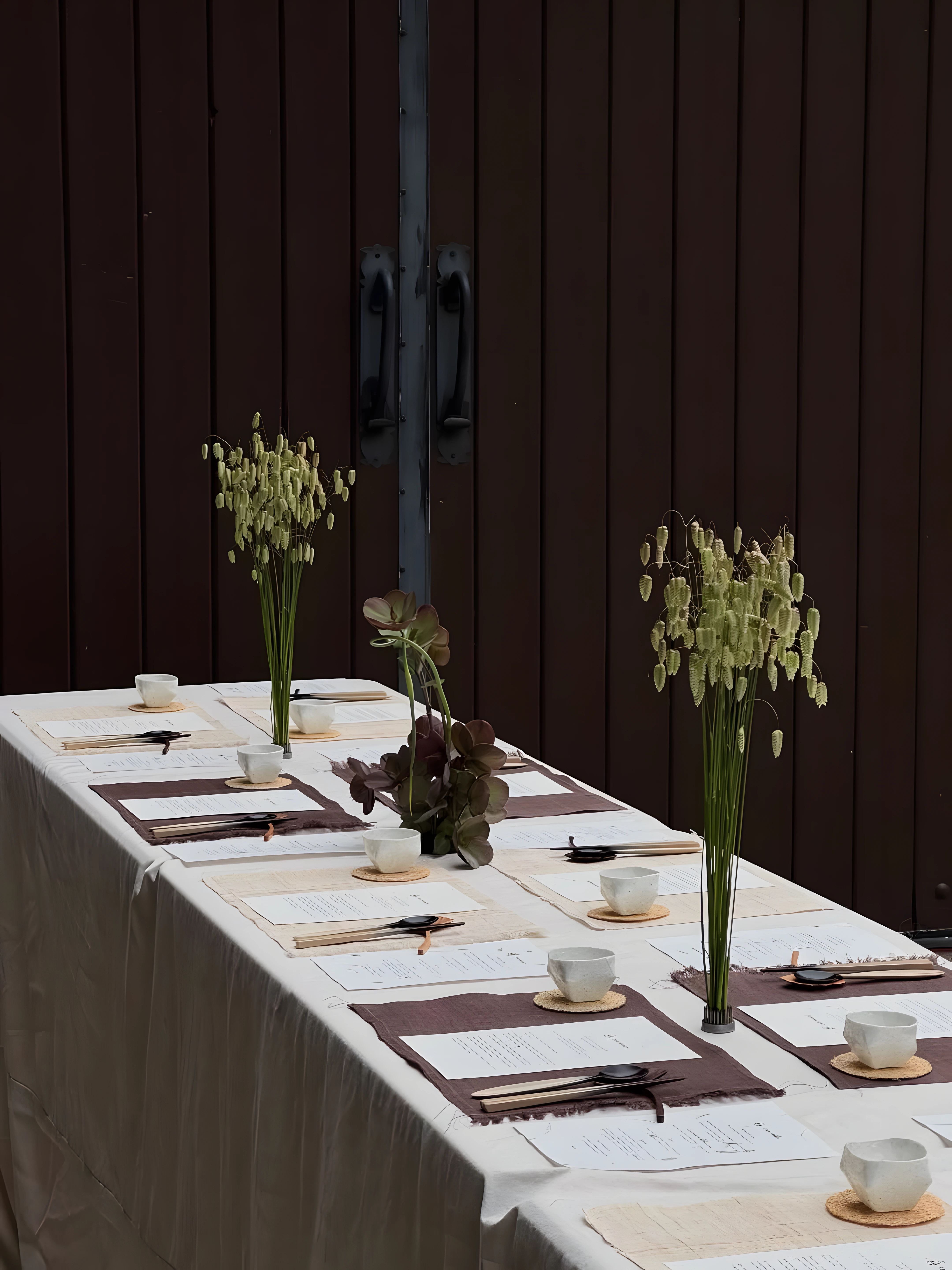 Long event table styled with tall botanical arrangements