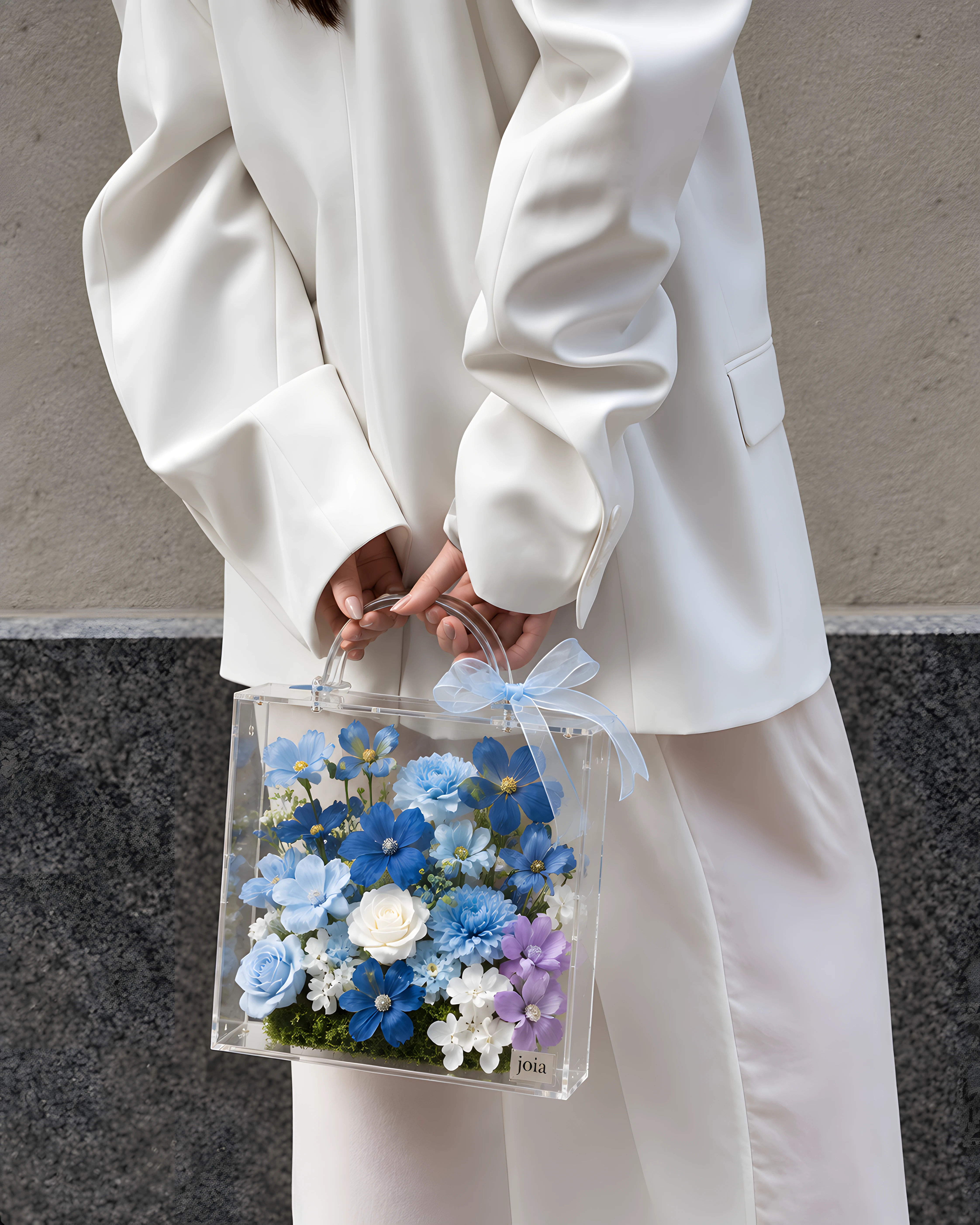 Woman in white carrying a blue JOIA flower valise