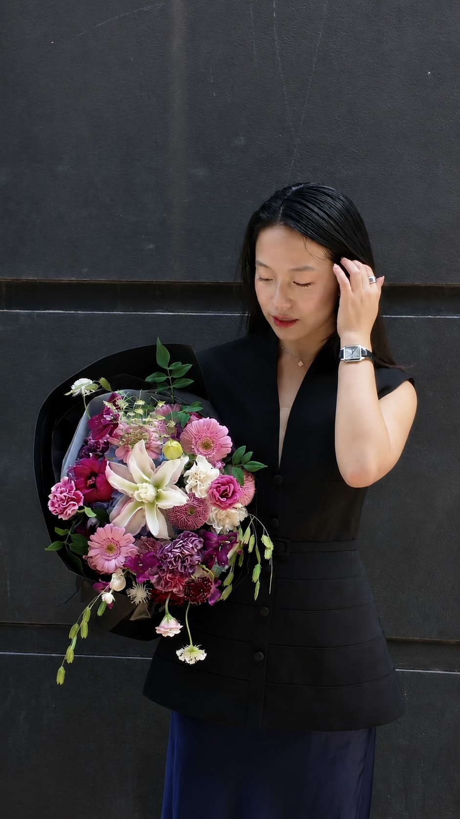 Jolie holding a bouquet of pink, purple, and ivory flowers