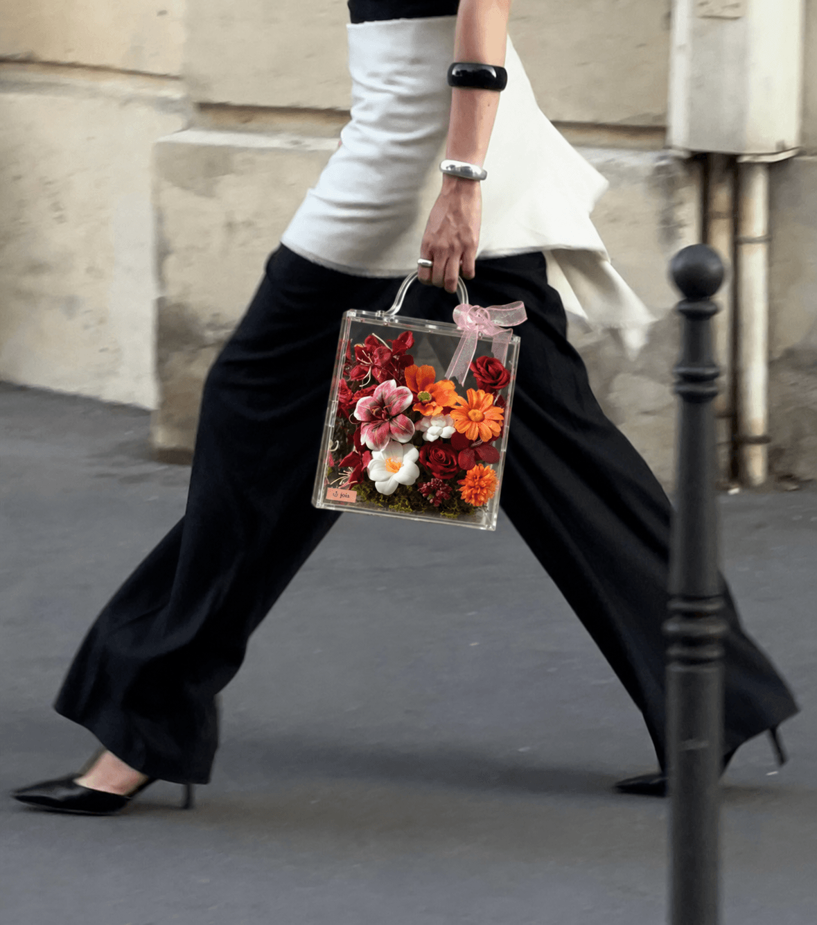 A warm-toned JOIA flower valise carried along a city street